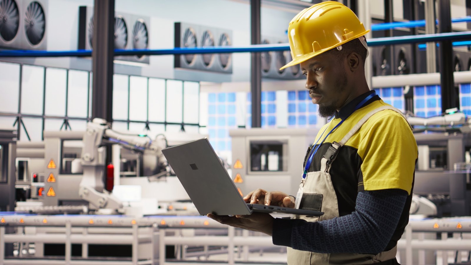 Engineer managing a smart factory with a laptop